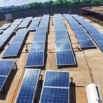 Vista panorámica de paneles solares sobre techo de una moderna fábrica en una zona industrial.