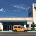 Camioneta eléctrica estacionada frente a un edificio moderno en Troy, Michigan, bajo un cielo claro