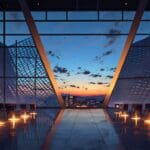 Moderno centro de conferencias en Valencia con diseño arquitectónico futurista, iluminado al atardecer.