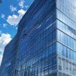 Edificio moderno corporativo rodeado de árboles y cielo despejado