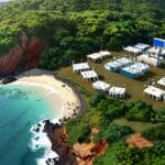 Vista aérea de un moderno centro de conferencias en una isla, rodeado de naturaleza y tecnología.