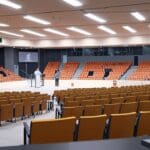 Vista panorámica del centro de conferencias de Córdoba con asistentes conversando en un entorno moderno y tecnológico.