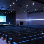 Escena moderna de un evento tecnológico con presentaciones digitales en un auditorio