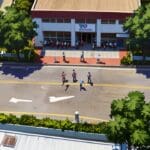 Vista aérea de un centro de votación en Ecuador durante las elecciones, rodeado de vegetación y personas en movimiento