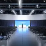 Centro de conferencias moderno con asistentes y tecnología avanzada en exhibición.