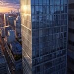 Vista aérea de un edificio moderno en un entorno tecnológico y urbano al atardecer.