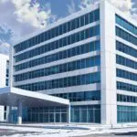 Edificio moderno de oficinas tecnológicas con montañas nevadas al fondo