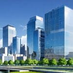 Panorámica de edificios empresariales innovadores en una ciudad junto a verdes colinas.