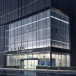 Fachada moderna de un edificio bancario con diseño innovador y tecnológico, en un entorno urbano sofisticado.