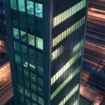 Modernos edificios de oficinas tecnológicas con luces encendidas al anochecer, vista desde un dron.