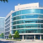 Edificio moderno de oficinas tecnológicas con árboles al fondo en un día soleado