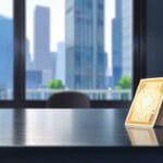 Primer plano de una tarjeta de crédito sobre una mesa, con fondo de ciudad tecnológica.