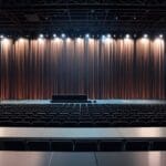Imagen de un auditorio moderno con un escenario brillante listo para una entrega de premios