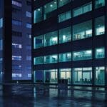 Oficinas modernas y tecnológicas con luces nocturnas en un entorno urbano.