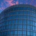 Edificio moderno de una empresa tecnológica iluminado al atardecer con un cielo despejado