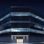 Moderno edificio corporativo tecnológico con luces nocturnas.
