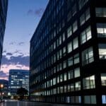 Silhouette de modernos edificios de oficinas en un centro tecnológico con luces iluminando al atardecer
