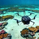 Imagen de dron de arrecifes de coral bajo el agua con equipos de tecnología ambiental restaurando el ecosistema.