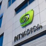 Fachada de edificio moderno de tecnología con logotipo de Nvidia destacándose contra un cielo nublado