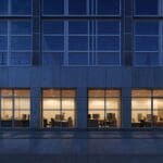 Edificios modernos y tecnológicos iluminados al anochecer con ambiente empresarial