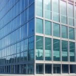 Edificio de oficinas modernas con fachadas de vidrio y luz natural en un entorno tecnológico urbano