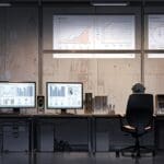 Oficinas modernas con computadoras y pantallas que muestran gráficos y datos de gestión documental