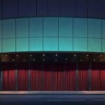 Exterior moderno de un teatro con fachada de vidrio y luz natural