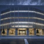 Exterior moderno de un edificio de oficinas tecnológicas en España, iluminación cálida y ambiente digital