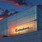 Edificio corporativo moderno con el logo de CaixaBank visible al atardecer