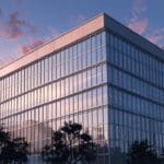 Edificio corporativo moderno rodeado de naturaleza al amanecer