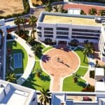 Vista aérea de un centro de conferencias moderno en Marbella rodeado de palmeras y edificios contemporáneos