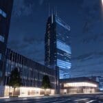 Un moderno centro tecnológico en España al anochecer, con luces brillando y edificios futuristas.