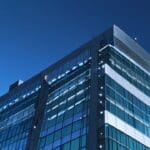 Edificio moderno con luces de tecnología y un cielo azul claro en el fondo