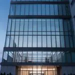 Vista de un moderno edificio de oficinas tecnológicas al anochecer.