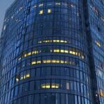 Edificio moderno con luces brillando al anochecer, simbolizando innovación y tecnología.