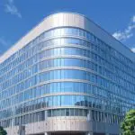 Edificio moderno de oficinas en un distrito tecnológico, con cielo despejado y luz diurna