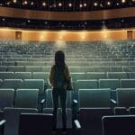 Auditorio moderno lleno de personas asistiendo a una conferencia de tecnología con pantallas grandes