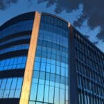 Edificio corporativo moderno en Cantabria, iluminado al atardecer, con un cielo limpio y azul