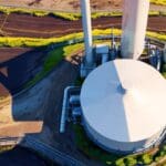 Vista aérea de una planta industrial sostenible rodeada de naturaleza.