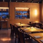 Interior de restaurante moderno con un toque tecnológico, mesas impecables, y una atmósfera elegante al atardecer.