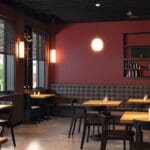 Interior de un moderno restaurante con tecnología avanzada y pantallas digitales.