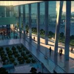 Vista aérea de un centro de convenciones moderno rodeado de áreas verdes al atardecer