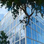 Edificio gubernamental moderno rodeado de árboles y cielo despejado