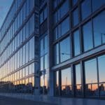 Conjunto de oficinas modernas con fachada de vidrio en una ciudad tecnológica al amanecer