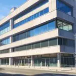 Fachada moderna de un edificio de oficinas con diseño tecnológico en una zona urbana de Castelldefels
