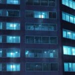 Edificios modernos en un centro tecnológico latinoamericano con cielos despejados y luces de oficinas encendidas al anochecer