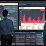 Oficina moderna con pantallas digitales mostrando datos y gráficos, ubicada en un entorno tecnológico de Barcelona