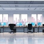 Oficinas modernas de una startup tecnológica con computadoras, pantallas y gráficos de crecimiento