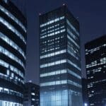 Edificios modernos en un distrito financiero europeo con luces encendidas al anochecer