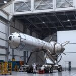 Instalaciones modernas de una empresa aeroespacial con cohetes en fase de ensamblaje dentro de un hangar tecnológico